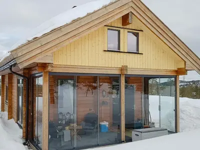 a house with glass doors on it in the snow at Charming Small Cabin At The Top Of Blefjell in Flesberg