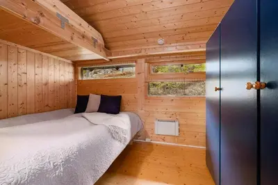 a small bedroom with a bed in a wooden cabin at Close To Nature In Ål Cabin At Haglebu in Eggedal
