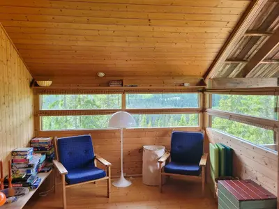 two blue chairs and a desk in a room with windows at Close To Nature In Ål Cabin At Haglebu in Eggedal