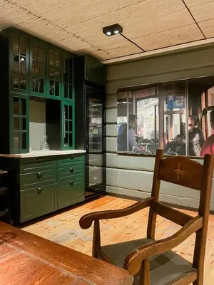 a kitchen with green cabinets and a wooden chair at Historic Old Rectory In The Heart Of Norway in Vestre Gausdal