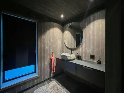 a bathroom with a round mirror and a sink at Stylish Cabin In Scenic Stryn in Stryn
