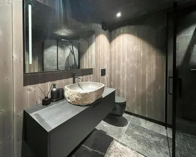 a bathroom with a stone sink and a toilet at Stylish Cabin In Scenic Stryn in Stryn