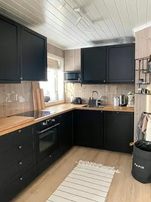 a kitchen with black cabinets and a sink at Cozy Cabin With Ski-Inout At Raulandsfjell in Rauland