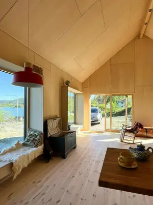 a living room with a couch and a table at Architect-Designed Cabin With Beach Nearby in Lensvik