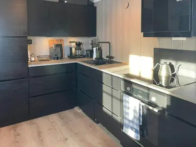 a kitchen with black cabinets and a stove at Cabin By The Cross-Country Trails In Norefjell in Eggedal