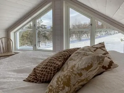 a bed with two pillows in front of a window at Traditional Cabin With Views Of Hardangervidda in Uvdal