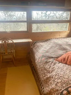 a bedroom with a bed and a table and a window at Ålhytte Near Vasetvannet in Ron