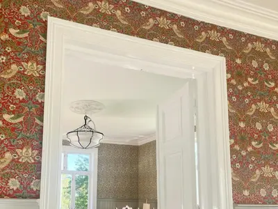 a room with red and gold wallpaper and a doorway at Historic Property In Idyllic Snertingdal in Segard