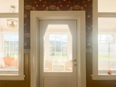 a door in a room with two windows at Historic Property In Idyllic Snertingdal in Segard