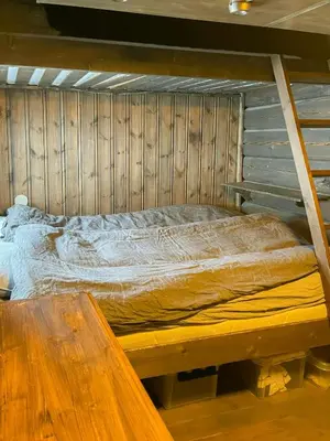 a bed in a room with a wooden wall at Log Cabin With Views Over Trysil Mountain in Trysil