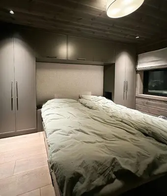 a bedroom with a large bed and cabinets at Unique Cabin With Spa And Ski In-Ski Out in Hemsedal