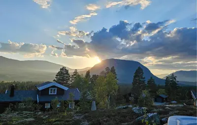 a house in the mountains with the sunset in the background at Amazing Home In Lesjaskog With Wifi in Bjorli