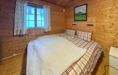 a bedroom with a bed in a log cabin at 2 Bedroom Pet Friendly Home In Rendalen in Rendalen