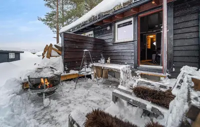 a log cabin with a fireplace in the snow at Amazing Apartment In Hovden I Setesdal in Hovden