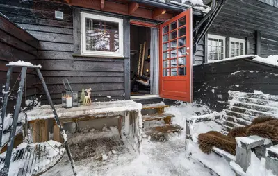 a house with a red door in the snow at Amazing Apartment In Hovden I Setesdal in Hovden