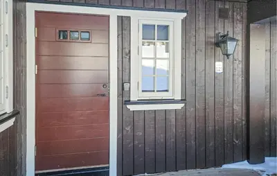 a red door and a window on a house at Lovely Apartment In Rjukan With Wifi in Rjukan