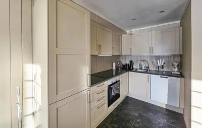 a kitchen with white cabinets and a black tile floor at Lovely Apartment In Rjukan With Wifi in Rjukan
