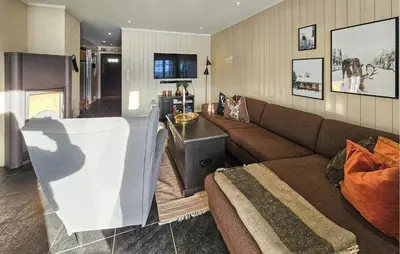 a living room with a brown couch and a table at Lovely Apartment In Rjukan With Wifi in Rjukan