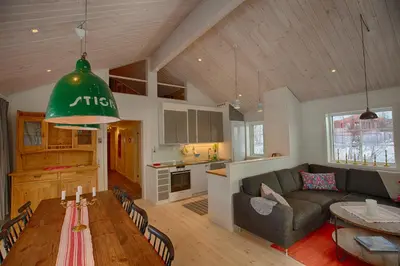 a living room and kitchen with a couch and a table at New 4Bedroom Cabin With Sauna, Terrace & Fireplace in Beitostøl