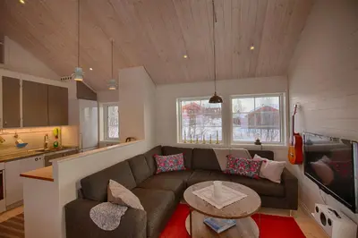 a living room with a couch and a table at New 4Bedroom Cabin With Sauna, Terrace & Fireplace in Beitostøl