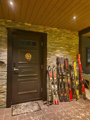 a door with a bunch of skis leaning against a brick wall at Trysil turistesenter hytte in Trysil