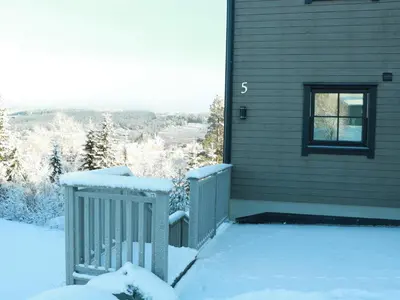 a snow covered porch of a house with a window at Trysil turistesenter liten leilighet in Trysil