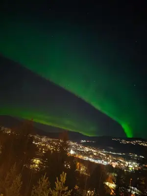 an aurora in the sky over a city at night at Trysil turistesenter liten leilighet in Trysil