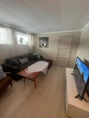 a living room with a couch and a tv at Sokkelleilighet i enebolig in Sula