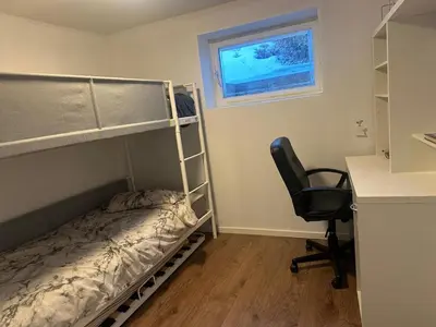a bedroom with a bunk bed and a desk and a chair at Gjestehus i Trondheim, under VM 2025 in Trondheim