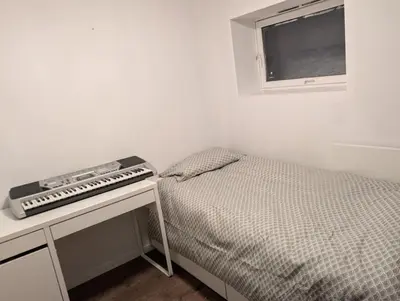 a bedroom with a bed and a keyboard on a table at Gjestehus i Trondheim, under VM 2025 in Trondheim