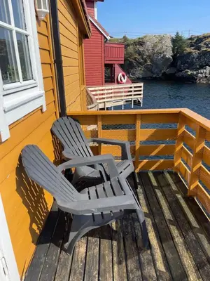 two chairs sitting on the deck of a house at Cozy Oceanfront Escape in Nautnes