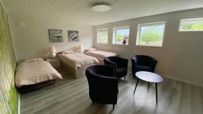 a room with two beds and a table and chairs at Apartment in Rauma in Veblungsnes