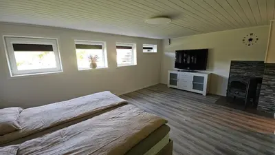 a bedroom with a bed and a flat screen tv at Apartment in Rauma in Veblungsnes