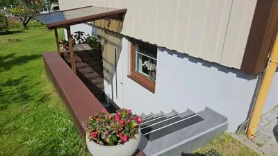 a small house with a window and some flowers at Apartment in Rauma in Veblungsnes