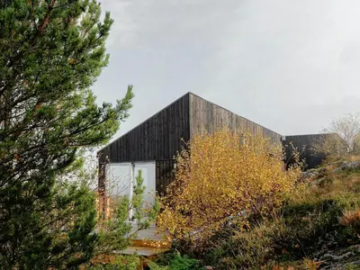 a black house on top of a hill at Architect Drawn Cabin With Sea View At Stokkøy in Hosen