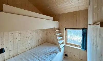 a small room with a bunk bed and a window at Architect Drawn Cabin With Sea View At Stokkøy in Hosen