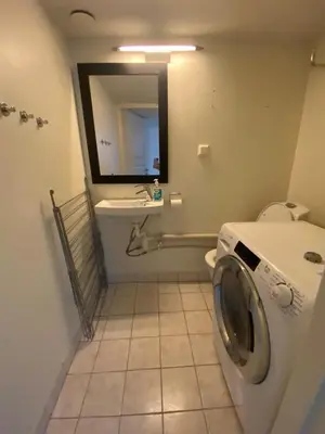 a bathroom with a toilet and a sink and a mirror at Central appartment with a nice view in Bergen