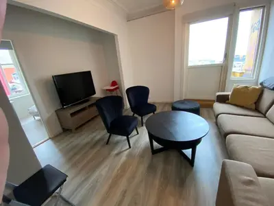 a living room with a couch and a table and chairs at Central appartment with a nice view in Bergen
