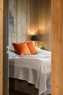 a bed with two orange pillows in a room at Family Cabin At The Foot Of Gaustatoppen in Rjukan