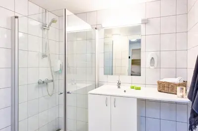 a white bathroom with a shower and a sink at Big And Modern Apartment At Beitostølen in Beitostøl