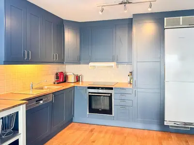 a kitchen with blue cabinets and a sink at Big And Modern Apartment At Beitostølen in Beitostøl