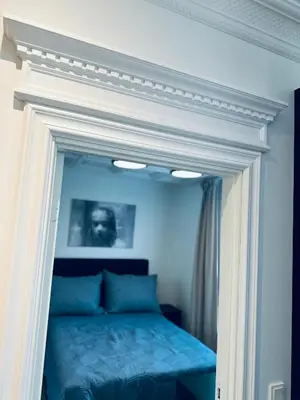 a bed with a white frame in a bedroom at Elegant Three-Bedroom Apartment with Stunning Sea Views - Limited availability - Secure your booking for Summer in Ålesund