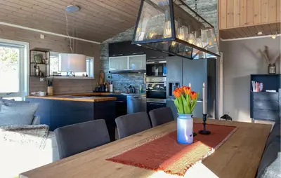 a kitchen with a wooden table with flowers in a vase at Stunning Home In Bjorli With Wifi in Bjorli