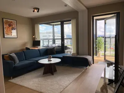 a living room with a blue couch and a table at Apartment in Trondheim, Tiller in Trondheim