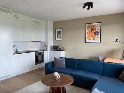 a living room with a blue couch and a table at Apartment in Trondheim, Tiller in Trondheim