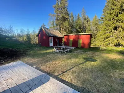 a red shed in the middle of a yard at Bekkvang Fjøs Tiny House in Trysil