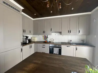 a kitchen with white cabinets and a wooden ceiling at Mountain Retreat Near Hiking And Skiing in Beitostøl