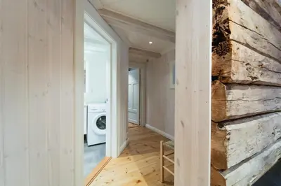 a laundry room with a stone wall and a washer and dryer at Leilighet i stall fra 1800-tallet in Os