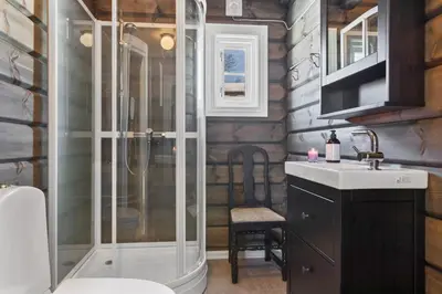 a bathroom with a shower and a toilet and a sink at New Timber Lodge With Stunning Views And Comfort in Beitostøl