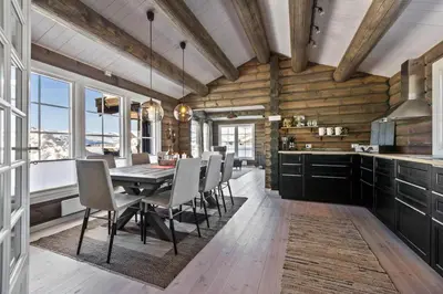 a kitchen and dining room with a table and chairs at New Timber Lodge With Stunning Views And Comfort in Beitostøl